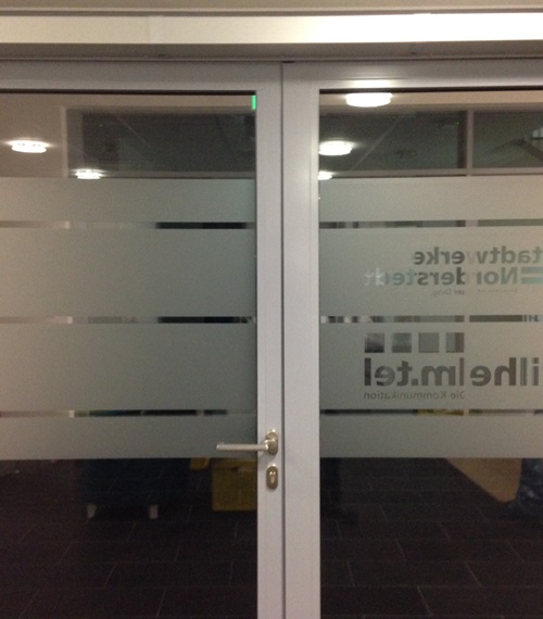 Milchglasfolie mit horizontalen Streifen und Firmenlogo auf Glastür – professioneller Sichtschutz und Werbetechnik von Folien-Fischer in Hamburg Bergedorf, Reinbek, Glinde, Geesthacht, Wentorf, Schwarzenbek, Barsbüttel, Lauenburg, Lüneburg und Aumühle